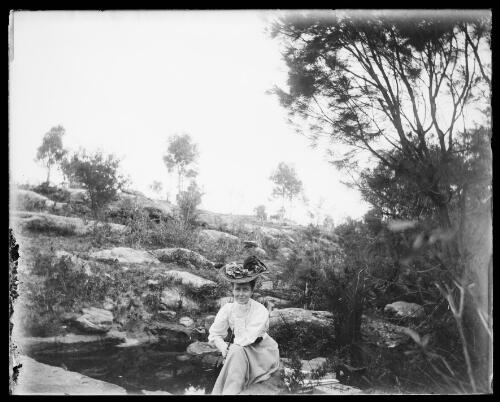 Jessie Violette Gabriel sitting in a rocky landscape, Gundagai region, New South Wales, between 1900 and 1910 [picture] / Charles Gabriel