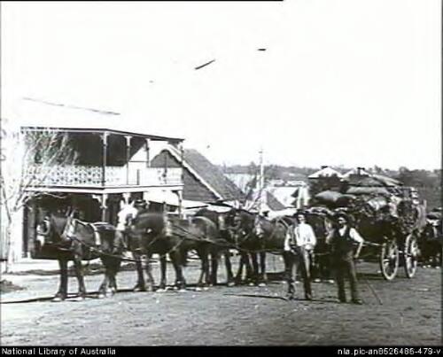 Two men standing in front of six horses and loaded wagon in front of Chivers Brothers building on Kendal Street, Mandurama, New South Wales [picture] / E.A. Lumme