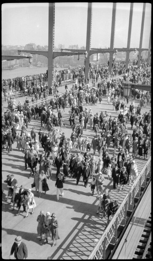 Crowds on roadway and tramlines looking south-east from the Sydney Harbour Bridge [picture] / Harold Cazneaux