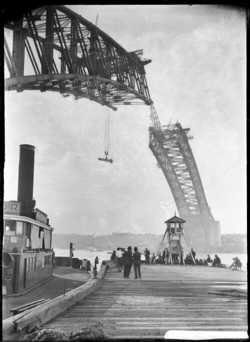 Arch over Dawes Point, Sydney Harbour Bridge, arch incomplete, girder being lifted [picture] / Harold Cazneaux