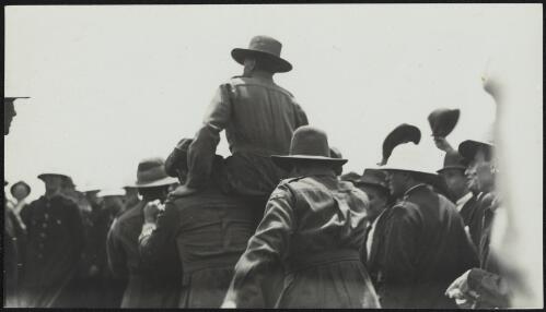 A soldier in broad-brimmed hat being carried on the shoulders of two others at Mascot, Sydney, 14 February 1920 / Harold Cazneaux