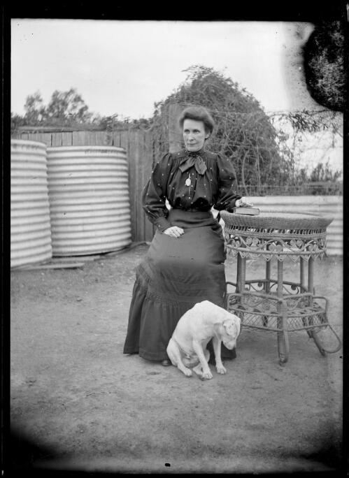 [Woman sitting by a cane table] [picture] / [William Henry Corkhill]