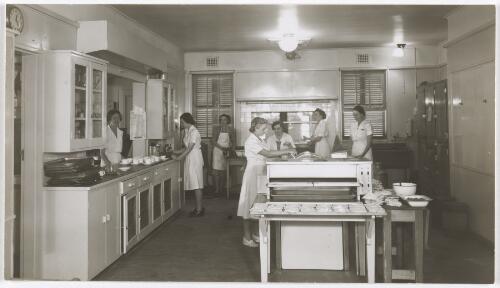 Seven women working in the Lady Gowrie Services Club kitchen, Manuka, Canberra, 1941? [picture] / R.C. Strangman