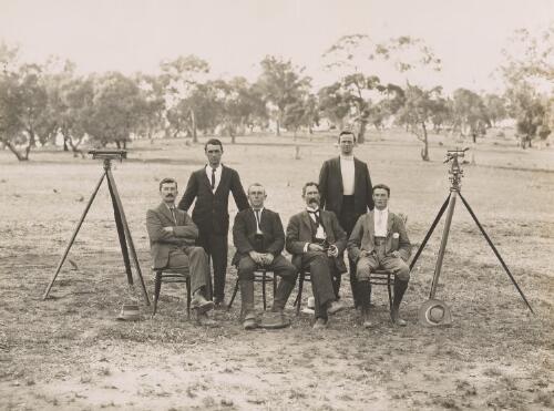Portrait of Federal Capital site surveyors, four seated and two standing, Camp Hill, Canberra, 1910 [picture]