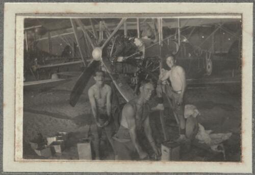 Three mechanics standing in front of a partially dismantled Royal Aircraft Factory B.E.2 biplane in a hangar, Middle East, ca. 1917 [picture] / Walter Henry Shiers