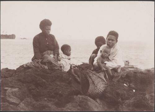 Two women with three children on the landing rock at Merelava, Banks Islands, 1906 / J.W. Beattie