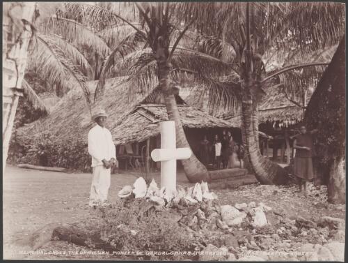 Man standing next to a memorial cross for the Christian pioneer of Guadalcanar, Maravovo, Solomon Islands, 1906 / J.W. Beattie