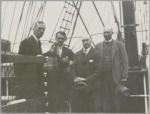 Captain J.K. Davis, Major R.G. Casey,  Dr. H.R. Mill,  Reverend J. Gordon Hayes on board the Discovery, July 1929 [picture] / Frank Hurley