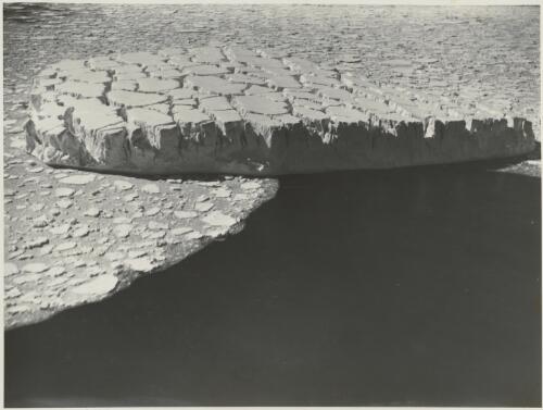 Aerial view of the crevassed surface of an iceberg drifting with the pack ice off the coast of MacRobertson Land, Antarctica, ca. 1930 [picture] / Frank Hurley