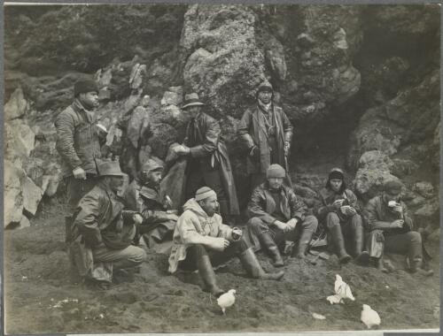 Expedition scientists taking a midday snack while collecting at the Crozet Islands, ca. 1930 [picture] / Frank Hurley