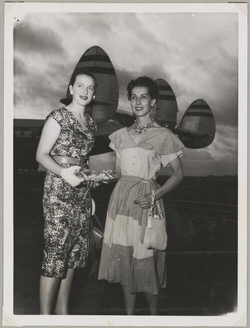 Annette Anderson with Dutch commercial pilot Liane Latour standing in front of the tail of Lockheed L-749A Constellation airliner PH-LDN on an airport tarmac, Sydney, 18 January 1955 [picture]