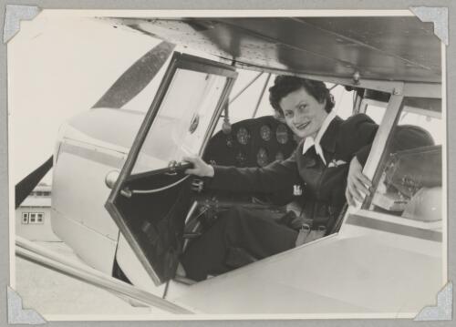 Australian Women Pilots' Association member Meg Cornwell in the cockpit of Auster J/5G Cirrus Autocar monoplane VH-ADY at an airfield, 1954 [picture]