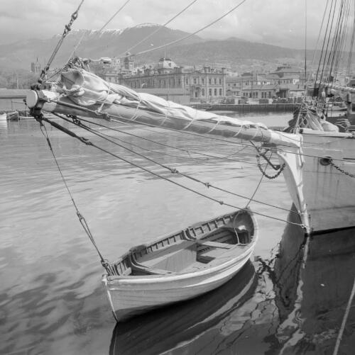 [Yacht with dinghy, Constitution Dock, Hobart, with city buildings and Mount Wellington in the background] [picture] / Frank Moore