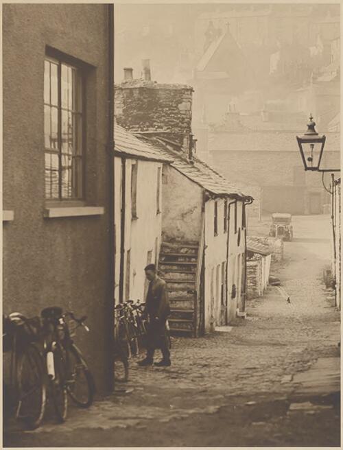 A young man standing near bicycles in village lane, Kendal, Cumbria [picture] / H.D. Dircks