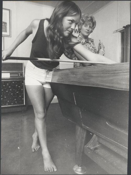 Apples, the governess, takes aim on the pool table at the hotel, Kulgera, Northern Territory, ca. 1972 [picture] / Bruce Howard