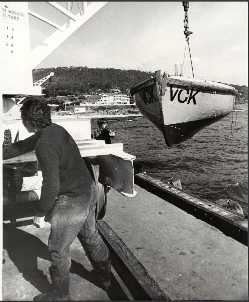 A boat being raised beside the wharf with the Pacific Hotel in the background, Lorne, Victoria, ca. 1972 [picture] / Bruce Howard
