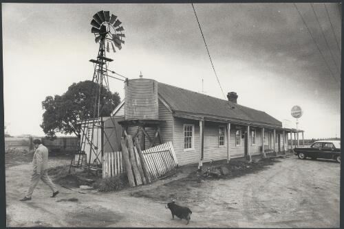 A man and dog in front of the Swiss Mountain Hotel, Blampied, near Daylesford, Victoria, ca. 1972 [picture] / Bruce Howard