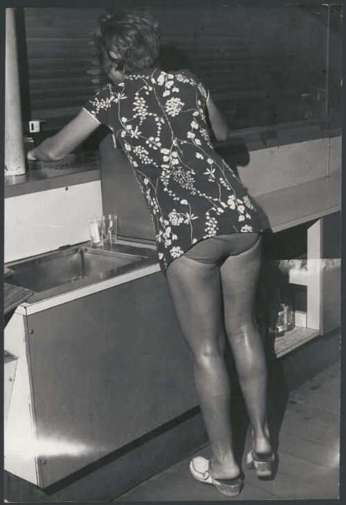 Barmaid cleaning the bar in the Esplanade Hotel, Port Hedland, Western Australia, ca. 1972, 2 [picture] / Bruce Howard