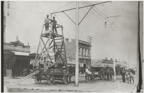 Attaching the tram lines to the poles using a horse drawn wooden scaffold, Kalgoorlie, Western Australia, 19 April 1902, 1 [picture]