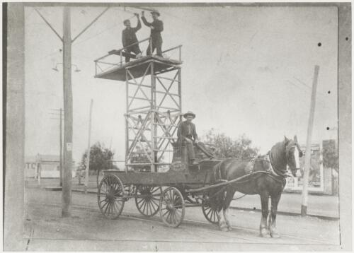 Attaching the tram lines to the poles using a horse drawn wooden scaffold, Kalgoorlie, Western Australia, 19 April 1902, 2 [picture]
