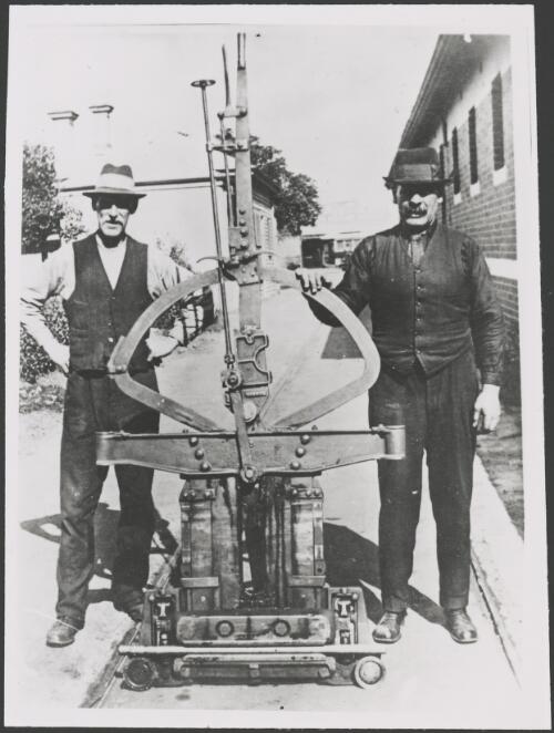 Two men with the grip mechanism of a cable tram, Melbourne, ca. 1890 [picture]