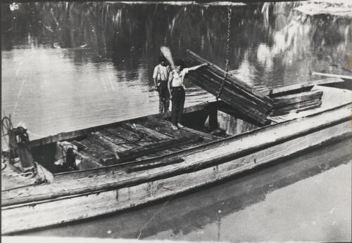 Two men loading a barge with railway sleepers, Swan Hill, Victoria, 1924 [picture] / Dennis Brabazon