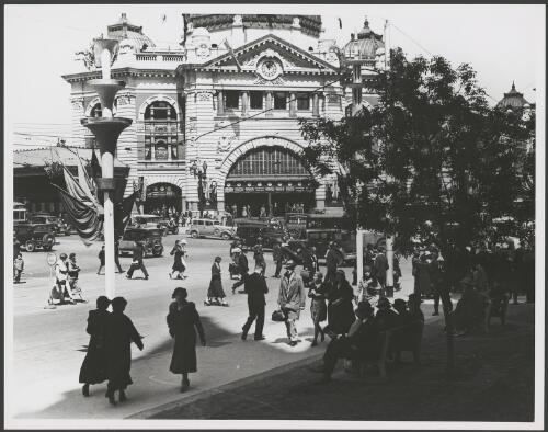 Street scene outside Flinders Street Station, which has been decorated with flags, Melbourne, ca. 1935, 1 [picture]