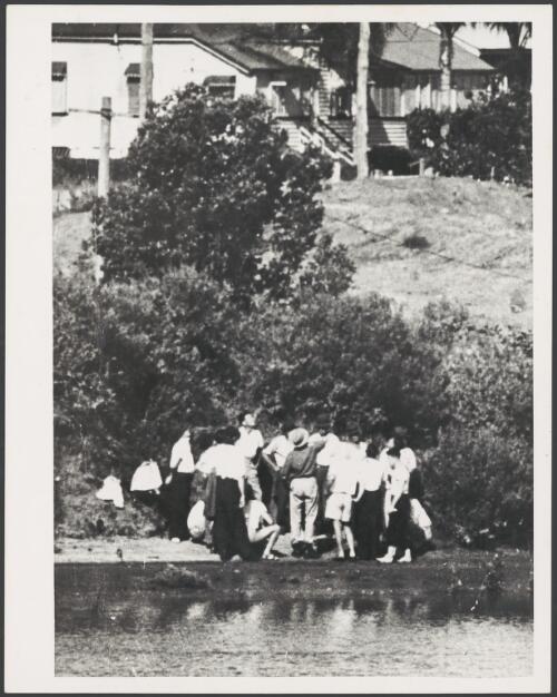 Group of people playing two-up by the river at New Farm, Brisbane, ca. 1920 [picture]