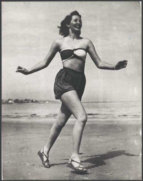 Model wears a two piece bloomer swimsuit and wedge-soled sandals on the beach, 1946 [picture]