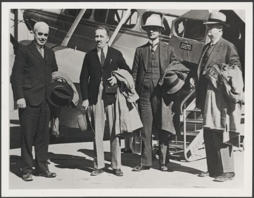 Four male passengers from overseas disembarking from a Qantas DH86 at Archerfield, Brisbane, 1936 [picture]