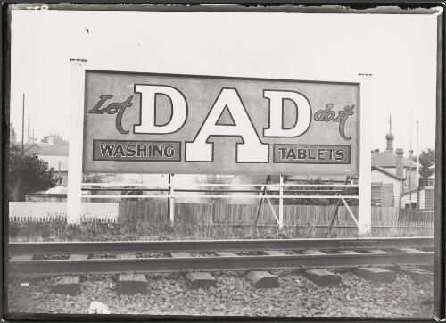Advertising billboard for Dad washing tablets beside railway track, Melbourne, ca. 1930 [picture]