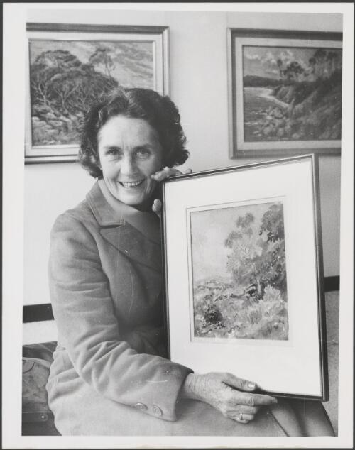 Jeanette Stedman, a Sydney artist, holding a watercolour that Norman Lindsay painted for her in the early 1950s as a demonstration of technique, New South Wales, ca. 1975, 1 [picture]