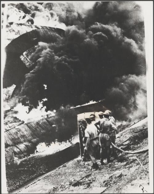 Oil storage tanks burning after being hit during the first Japanese air raid on Darwin during World War II, Darwin, 19 February 1942 [picture]