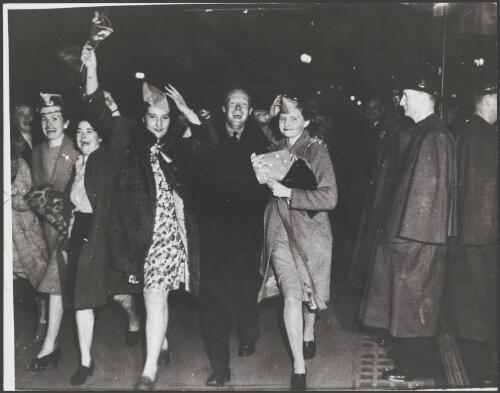 Police guard shop windows as people wave flags during victory celebrations in Bourke Street, Melbourne, 15 August 1945 [picture]