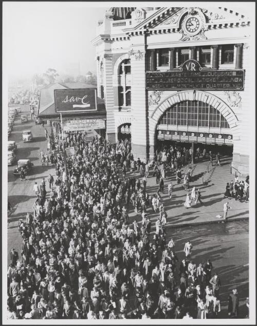 Pedestrians cross Flinders Street at the corner of Swanston Street in front of Flinders Street Station, Melbourne, ca. 1945 [picture]
