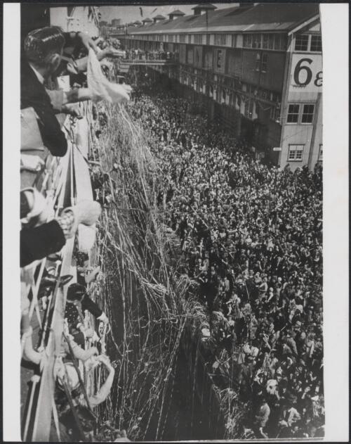 A crowd welcomes a ship, possibly bearing European migrants, arriving at pier, Melbourne, ca. 1950 [picture]