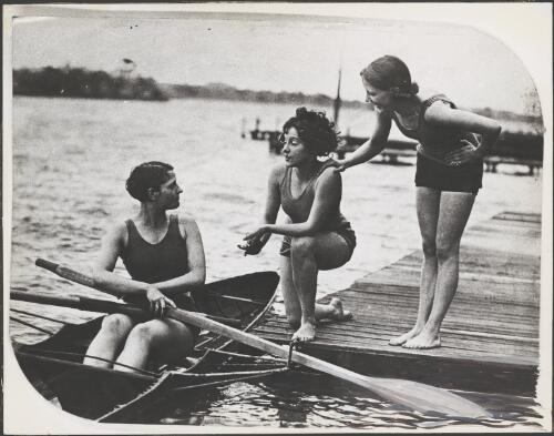 Female single sculler speaking to two women on a jetty, South Australia, ca. 1928 [picture]