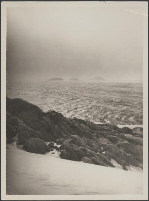 [View of the ocean taken from a rocky ledge, three dark masses appear in background, Australasian Antarctic Expedition, 1911-1914] [picture] / McLean