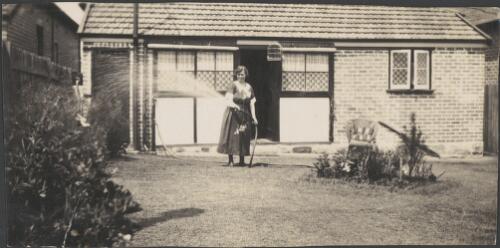 Elizabeth Haynes' sister watering a garden with a hose, Sydney, approximately 1930, 1 / Albert Dryer