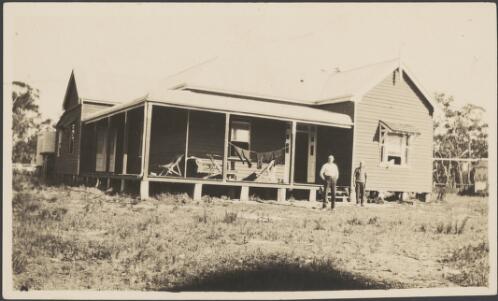 Two men standing in front of a weatherboard house, approximately 1930 / Albert Dryer