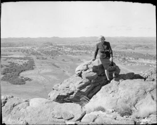 Mrs Searle sitting on rocks at Heavitree Gap, Alice Springs, Northern Territory, 1947 [picture] / E.W. Searle