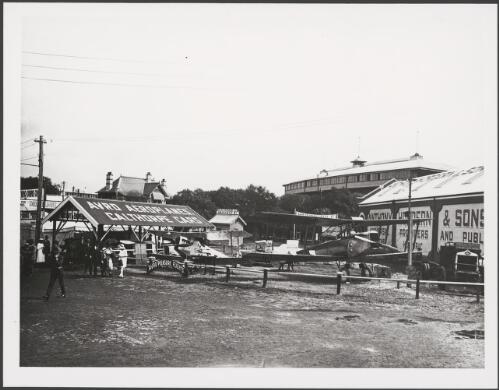 Two Avro aircraft parked amongst cars to advertise Avro pleasure flights, Sydney Showground, 1920 [picture] / E.W. Searle