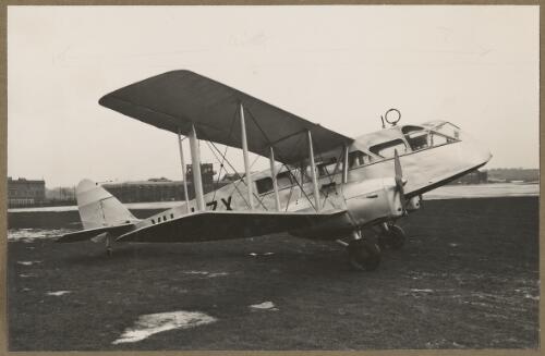 De Havilland DH.84 Dragon light commerical aircraft VH-UZX on an airfield [picture] / E.W. Searle