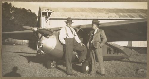 Two unidentified men next to Praga E.114 Baby sport monoplane VH-UVP at Camden airfield, New South Wales, 1939 [picture] / E.W. Searle