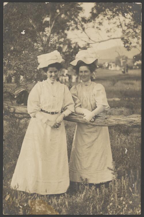 Portrait of two women leaning on fence rail, ca. 1910 [picture]