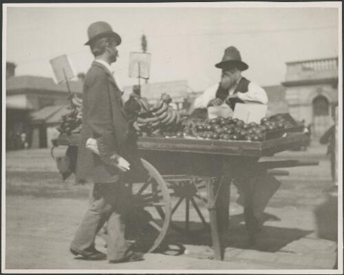 Man selling fruit from a hand cart in a Melbourne street, Melbourne, ca. 1902 [picture] / E.W. Searle
