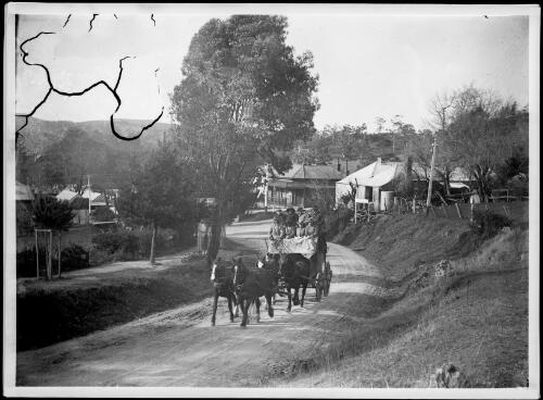 Stagecoach rounding a bend with houses in the background, Australia, ca.1900 [picture] / E.W. Searle