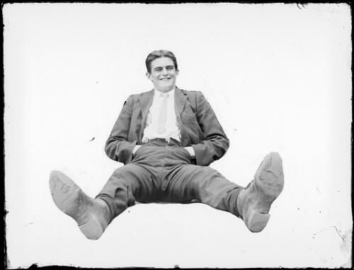 Laughing man, seated on the ground with his hands in his pockets, Australia, ca. 1900 [picture]