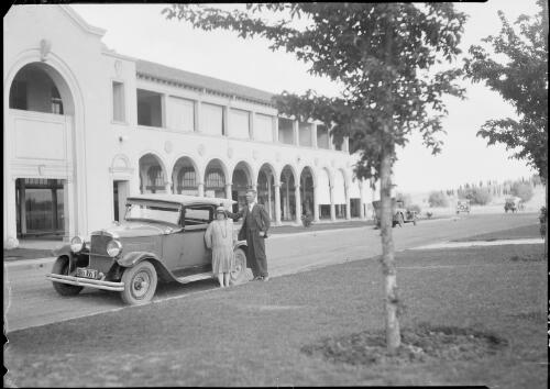 Man and a woman standing beside a car, Sydney Building, Northbourne Avenue, Civic, Canberra, ca. 1929 [picture] / E.W. Searle