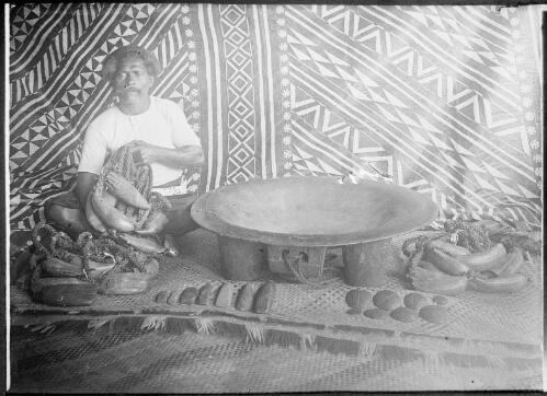 Man sitting on a woven mat beside a large bowl, Fiji, ca. 1920 [picture] / E.W. Searle
